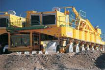 Figure 4. One of two massive ALMA transporters undergoes tests at the 16400 foot Array Operations Site. The APEX antenna, which is similar to the Vertex prototype antenna, can be seen through the undercarriage. Photo by A. Beelen.